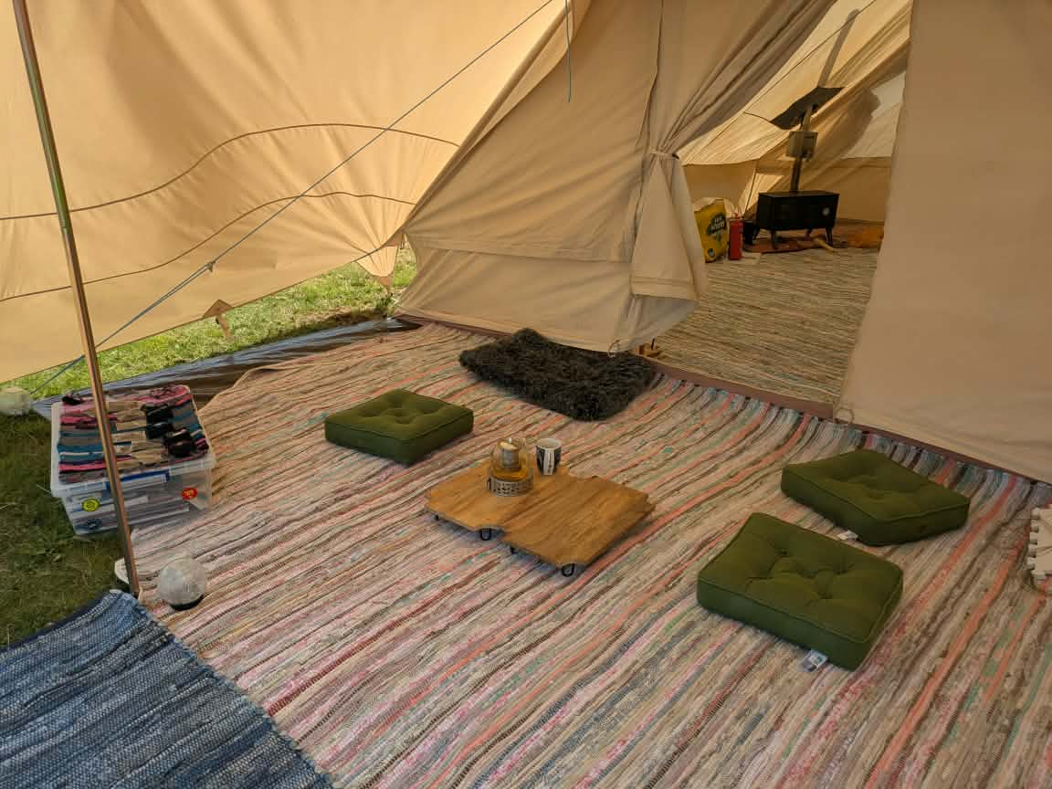 Woven rugs, cushions and a low craft table inside the workshop tent